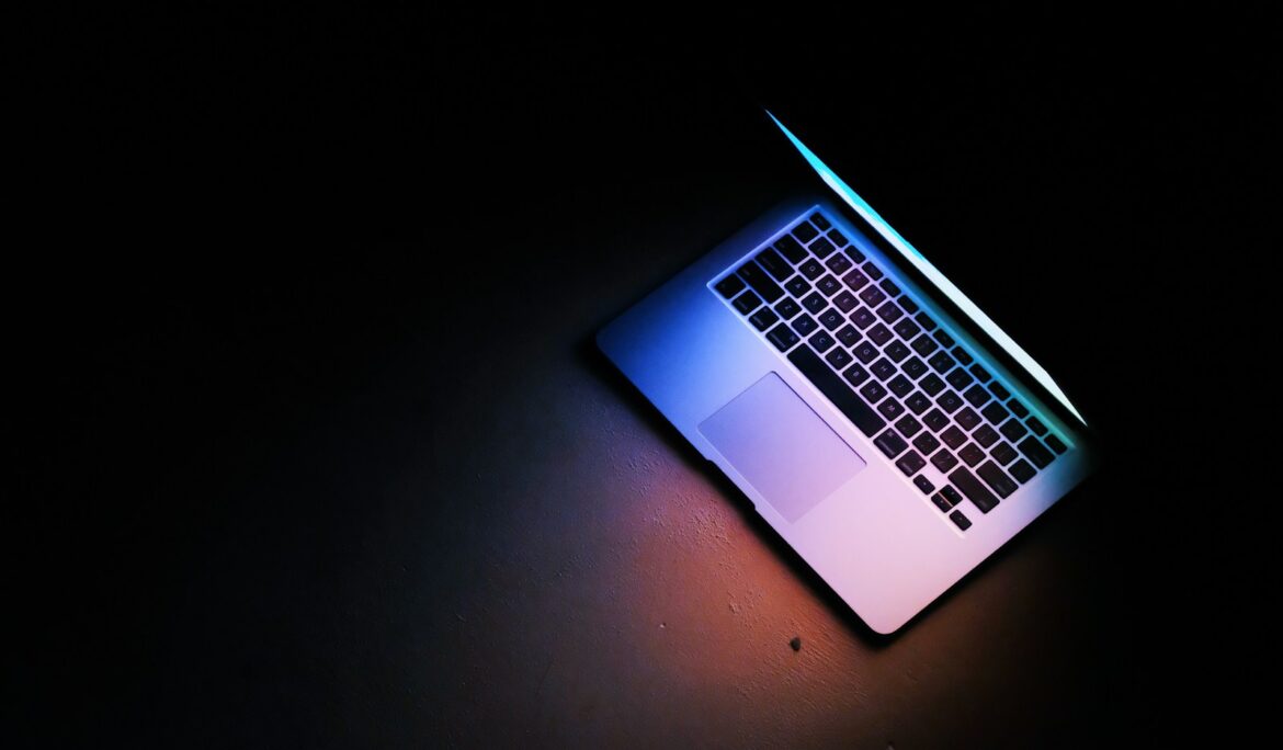 silver macbook air on black table