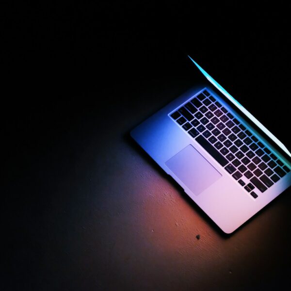 silver macbook air on black table