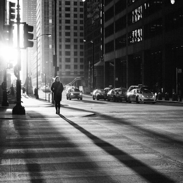 grayscale photo of woman walking on road